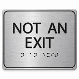 ADA Compliant Not an Exit Sign – 6"x5" Tactile with Braille — Brushed Aluminum studio view; reference SKU NAE65K-BRUSH.